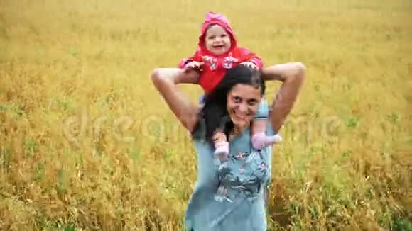 快乐的母亲带着孩子在麦田里笑视频的预览图
