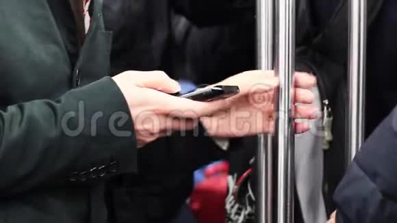 年轻人一边拿着手机一边拿着地铁酒吧视频的预览图