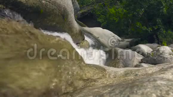 山河从瀑布上流过在雨林中的大石头上以瀑布瀑布的形式流淌山河视频的预览图