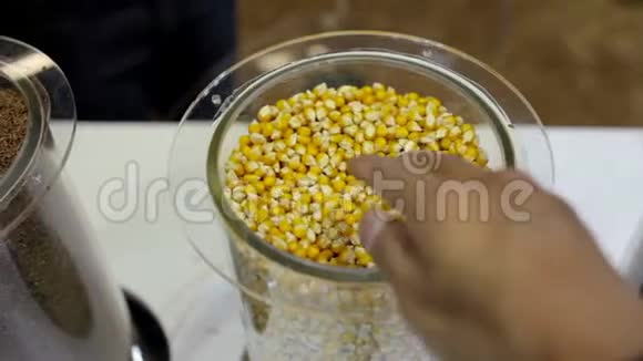 人类的手在玻璃容器中触摸玉米种子视频的预览图