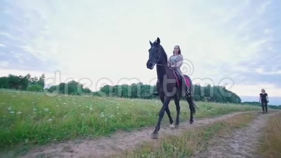 年轻的女马术运动员在马背上飞驰穿过草地视频的预览图