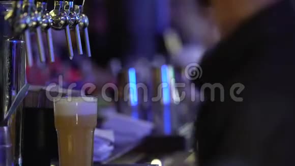 酒吧员工递给顾客一大杯带有泡沫白色泡沫的新鲜啤酒视频的预览图