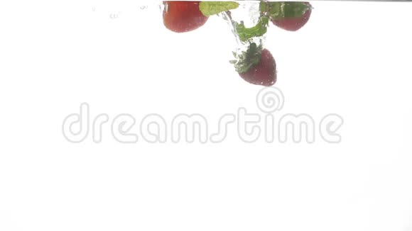 在白色背景下薄荷叶和成熟草莓在冷水中飞溅的特写慢镜头视频的预览图