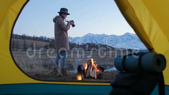 年轻人在平静的夏夜中在红帐篷里与单反拍照视频的预览图