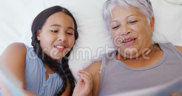 外婆和孙女一起在4k床房看相册视频的预览图