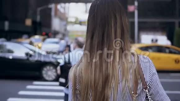 在纽约美国年轻美丽的女人穿过马路的后景坐着马车和出租车的女人视频的预览图