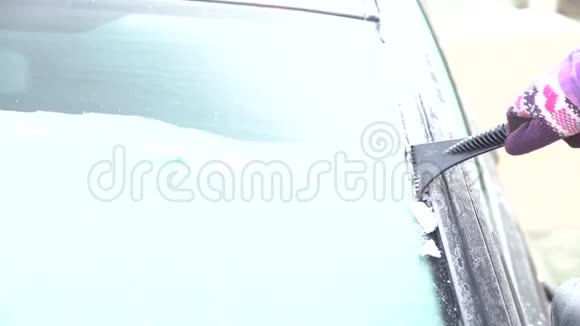 女人用刮刀把车窗从冰雪中擦干净视频的预览图