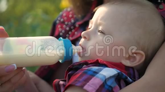 快乐妈妈在户外给婴儿奶瓶喂奶视频的预览图