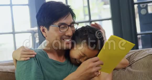 父亲和女儿在4k客厅读贺卡视频的预览图