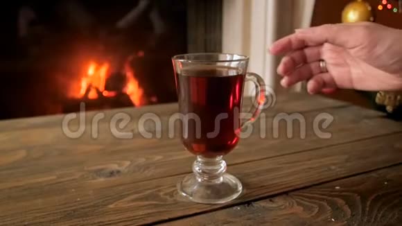 女子圣诞节在壁炉旁放松和喝茶的慢动作视频视频的预览图