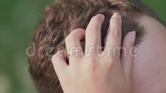夏日的浪漫情侣在林间空地上女孩手摸着那家伙头发温柔特写镜头视频的预览图