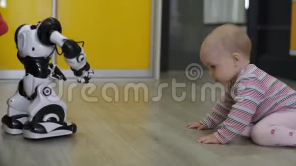 小女孩仔细地看着玩具机器人和他一起跳舞现代机器人技术视频的预览图