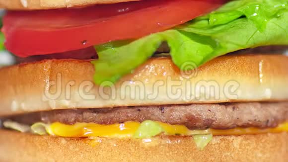 极致的特写镜头旋转开胃汉堡搭配烤牛肉切块番茄奶酪和生菜视频的预览图