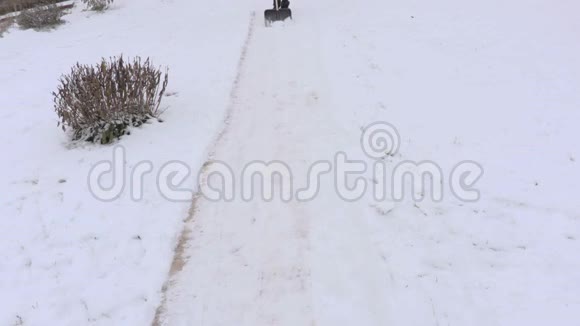 带着雪铲去路上的雪的女人视频的预览图