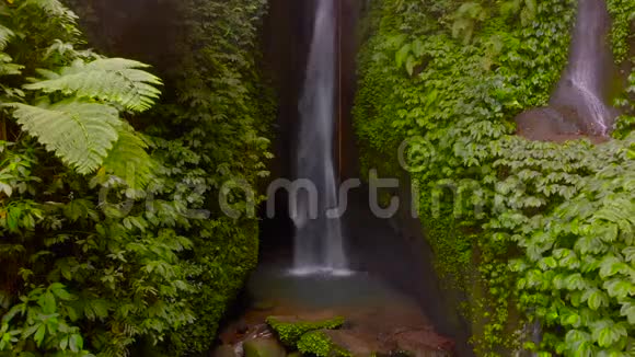 在印度尼西亚巴厘岛的丛林里的莱克勒克瀑布的鸟瞰图医生慢慢向左移动视频的预览图