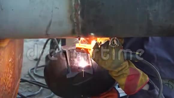 一名焊工在俄罗斯的炼油厂用手工电弧焊接工艺管道焊接接头视频的预览图