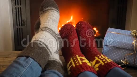 圣诞前夜一对情侣在壁炉旁温暖双脚的特写慢动作视频视频的预览图