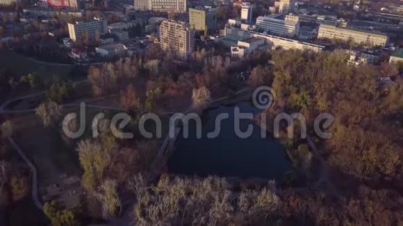 图片空中4k无人机飞行在平静的小城市景观与镜面湖公园日落视频的预览图