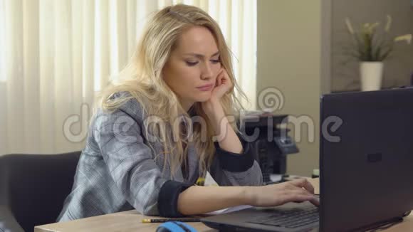 疲惫的金发女郎在办公室的工作场所睡着了视频的预览图