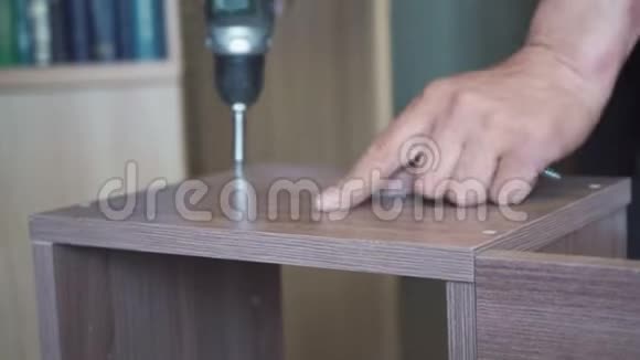 工人用螺丝刀和螺丝组装木制家具视频的预览图