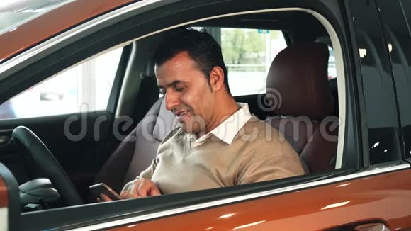 坐在车里的一个兴高采烈的人拿着钥匙自拍视频的预览图