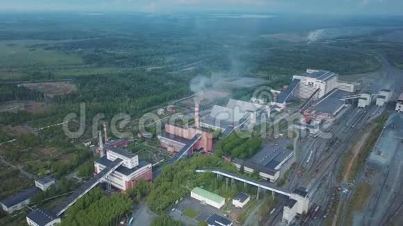 鸟瞰植物工业建筑与高大的烟囱周围的森林生产系统视频的预览图