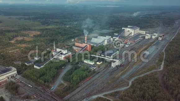 鸟瞰植物工业建筑与高大的烟囱周围的森林生产系统视频的预览图