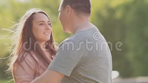 浪漫的情侣在公园拥抱快乐地盘旋着相互亲吻视频的预览图