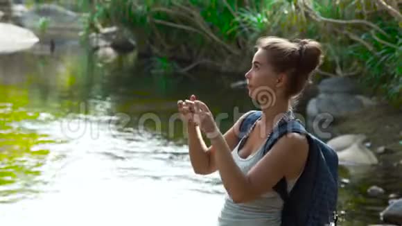 在丛林森林徒步旅行时旅行妇女使用手机拍照女游客拍摄智能手机视频视频的预览图