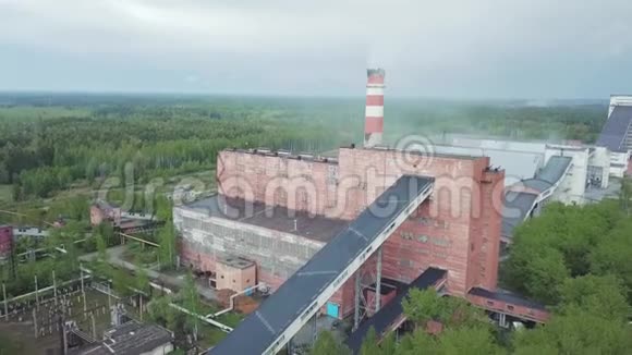 古老的红色工业厂房高烟囱对抗灰色的雨天空中观景视频的预览图