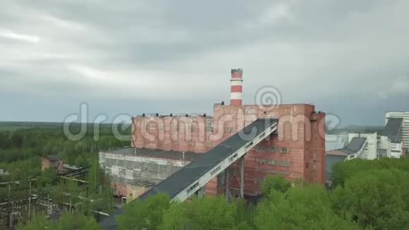 古老的红色工业厂房高烟囱对抗灰色的雨天空中景观视频的预览图