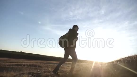日落时带背包的游客穿过群山健康生活方式的概念视频的预览图