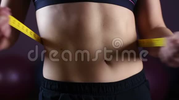 女性平腹特写女性用测量胶带显示减肥结果视频的预览图