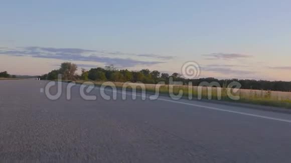 从田野上的一辆移动的汽车和五彩缤纷的日落中观看大自然有一扇车窗视频的预览图