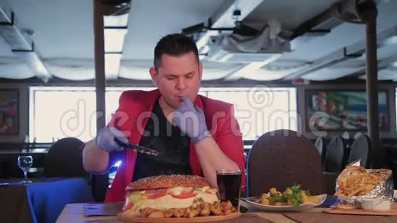 一个男人用刀切了一个大汉堡视频的预览图