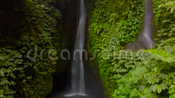 在印度尼西亚巴厘岛的丛林里的莱克勒克瀑布的鸟瞰图医生慢慢地视频的预览图