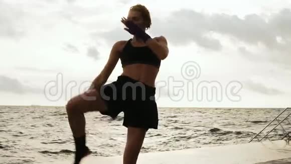 空手道女运动员在海边缓慢地向太阳踢腿美女拳击手视频的预览图