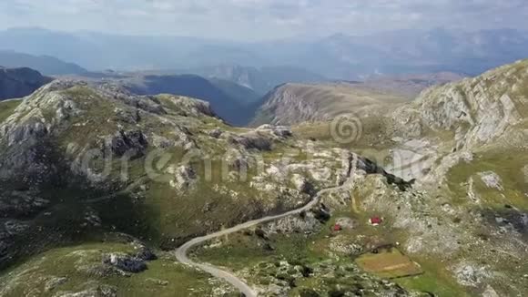 无人驾驶飞机飞越黑山丘陵和田野的两条车道背景是4k的岩石视频的预览图