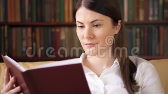 年轻的女人在家看物理印刷书旧传统经典纸质阅读理念视频的预览图