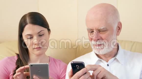 父女使用智能手机浏览阅读新闻科技时代理念中的孤独视频的预览图