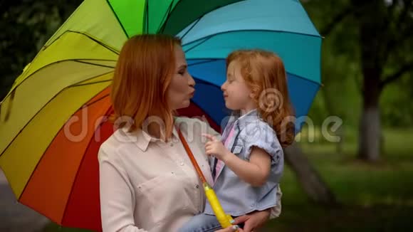 彩虹伞下快乐的妈妈和孩子视频的预览图