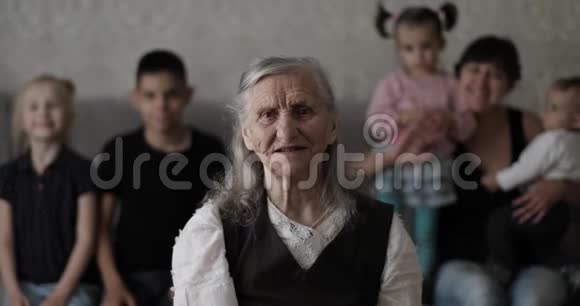 一个有一个大家庭的老白发奶奶的肖像视频的预览图