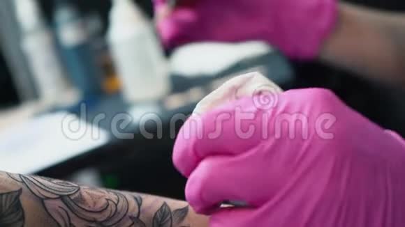 乌克兰基辅2018年5月20日艺术家的双手为顾客做纹身纹身艺术家戴着粉红色的手套做纹身视频的预览图