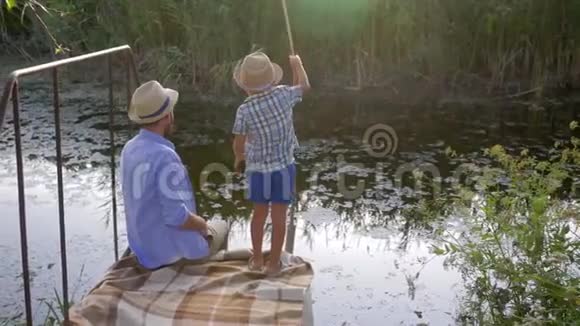 小男孩和他的父亲在湖边钓鱼度假时家庭娱乐视频的预览图