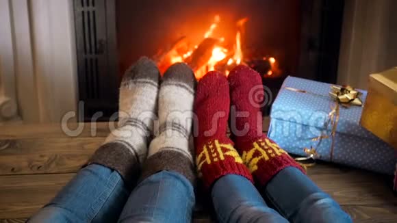 两个人穿着针织毛袜在家中壁炉旁休息的慢镜头视频的预览图