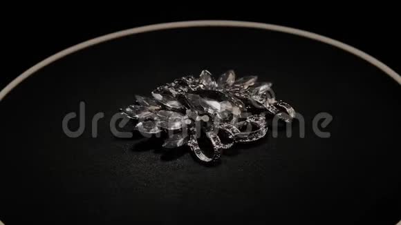 在一个黑色的旋转支架上用石头打胸针高级珠宝宏视频的预览图
