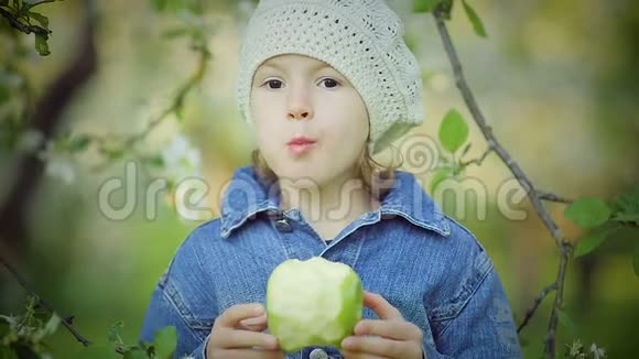 公园里吃绿苹果的小女孩的肖像视频的预览图