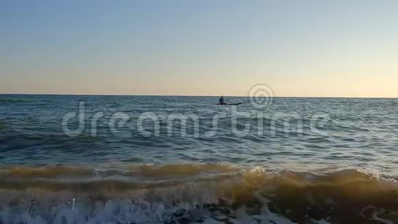 运动员的剪影在冲浪板上划桨慢动作视频的预览图