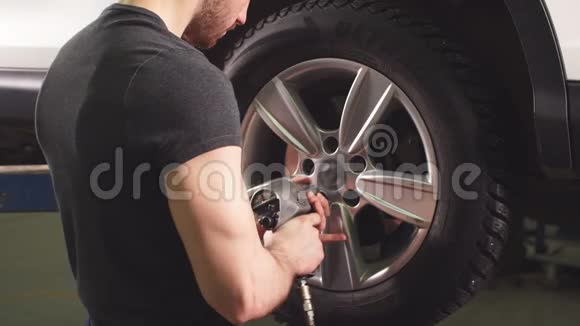 汽车修理厂的汽车修理工在更换车轮视频的预览图