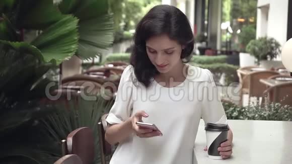 超级慢动作年轻的商务小姐在城市咖啡馆有智能手机视频的预览图